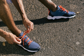 Close up of male athlete tying sport shoes shoelaces