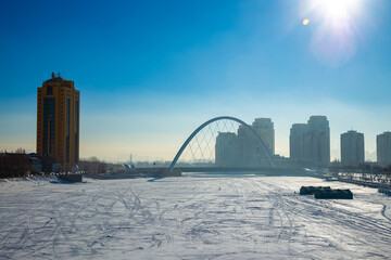 Obraz premium Astana Kazakhstan Skyscrapers and different commercial buildings in the downtown on Yesil River side with bridge. Colorful night in Astana, capital of Kazakhstan. Reflection on ice.