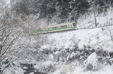 雪の積もった中走る叡山電鉄