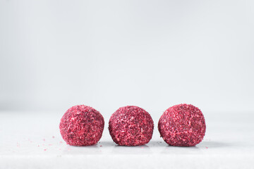 Raspberry coconut and chocolate truffles, homemade chocolate bonbons on white background