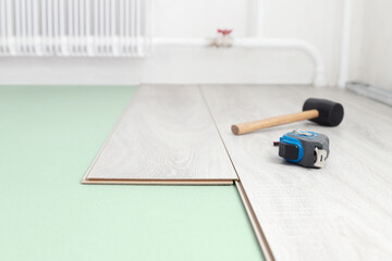 Laying laminate and soundproofing on a concrete floor. Repair and decoration of premises. Modern flooring. Soft focus.