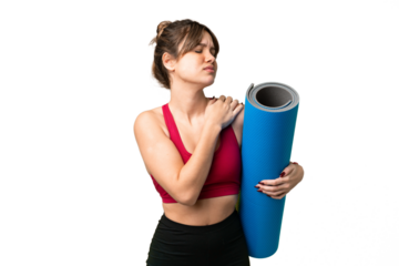 Young sport girl going to yoga classes while holding a mat over isolated chroma key background suffering from pain in shoulder for having made an effort