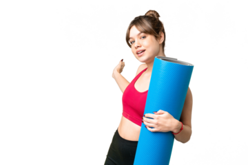 Young sport girl going to yoga classes while holding a mat over isolated chroma key background extending hands to the side for inviting to come