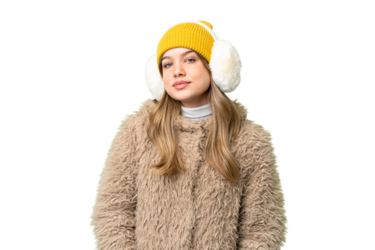 Young girl wearing winter muffs over isolated chroma key background laughing