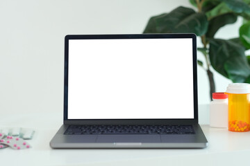 Fototapeta premium Laptop mock up, Laptop computer with blank screen and medicines on docter table
