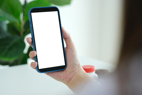 Mock Up Mobile Phone, Docter Woman Hand Holding Smart Phone With Blank On Screen And Medicine On Desk At Clinic Office