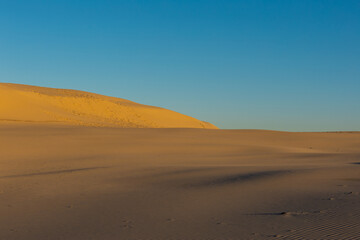 Fototapeta na wymiar Empty sand dune with blue sky.