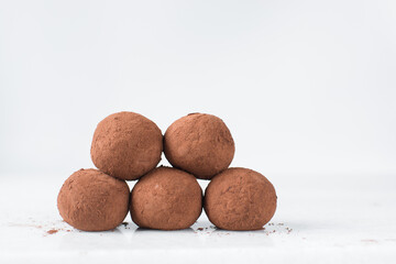 chocolate truffles covered in cocoa powder, homemade chocolate bonbons on white background