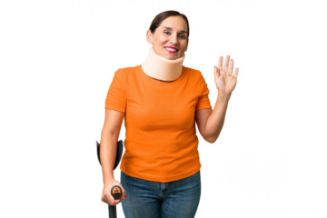 Middle-aged caucasian woman wearing neck brace over isolated background saluting with hand with happy expression