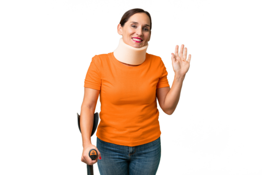 Middle-aged caucasian woman wearing neck brace over isolated background saluting with hand with happy expression