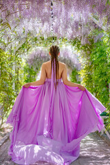 Fototapeta premium Woman wisteria lilac dress. Thoughtful happy mature woman in pur