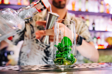 bartender preparing mojito cocktail drink in bar