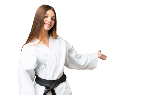 Teenager girl doing karate over isolated chroma key background extending hands to the side for inviting to come