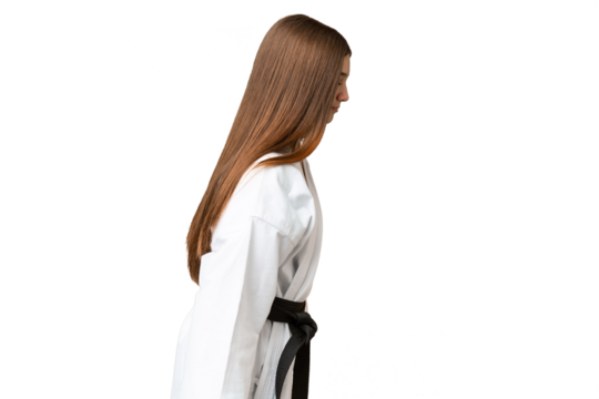 Teenager girl over isolated chroma key background doing karate and saluting