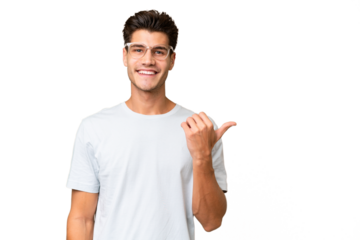 Young caucasian handsome man over isolated background pointing to the side to present a product