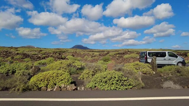 Black volcanic lava stones and yellow sand by the sae in ocean beach in Lanzarote , Spain - Summer holidays in Canary Islands biosfere reserve 