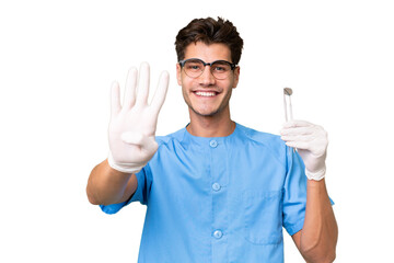 Young dentist man holding tools over isolated background happy and counting four with fingers