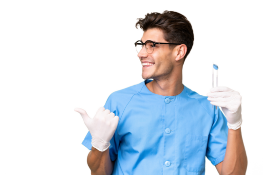 Young dentist man holding tools over isolated background pointing to the side to present a product