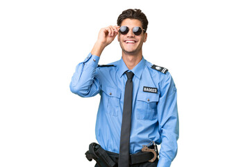 Young police man over isolated background with glasses and happy