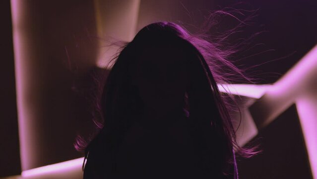 Close up portrait of pretty brunette female model . Beautiful attractive face of young woman . Hair flowing or blowing in wind . Face Changes Depending on the Lighting . Shadow and light movement . 