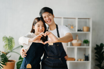 Happy asia young couple cooking together with vegetables with Bread and fruit in cozy on wooden kitchen table, love and valentine  sweet home