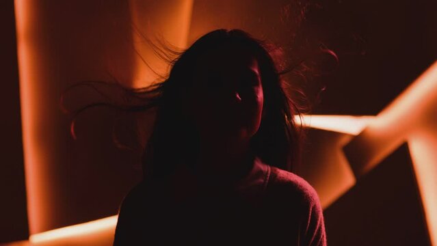 Close up portrait of pretty brunette female model . Beautiful attractive face of young woman . Hair flowing or blowing in wind . Face Changes Depending on the Lighting . Shadow and light movement . 