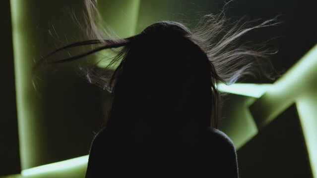 Close up portrait of pretty brunette female model . Beautiful attractive face of young woman . Hair flowing or blowing in wind . Face Changes Depending on the Lighting . Shadow and light movement . 