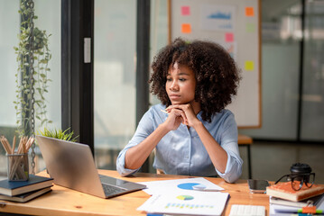 Black woman sitting in front of her considering work, office work  Business woman sitting thinking work concept