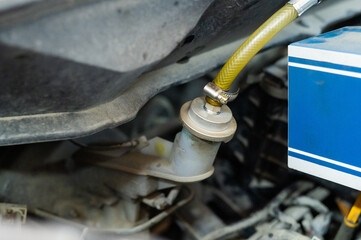 Automated change of brake fluid in a car service. Car bonnet.