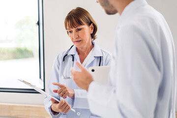 Group of professional medical doctor team work with stethoscope in uniform working discussing and talk together walking in hospital.health insurance medical care concept.