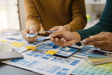 UI developer and ui designer brainstorming about mobile app interface wireframe design with...