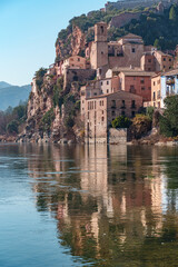 Fototapeta na wymiar Old town of miravet with the templar castle on the top and the ebro river flowing quietly on a sunny day.
