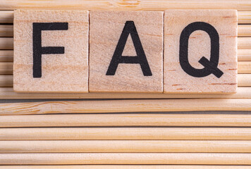 Wooden cube blocks with FAQ text (frequently asked questions) on  a light wooden background. Financial, marketing and business concepts