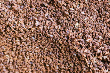 The grains of ground black coffee are very close. Close up groun