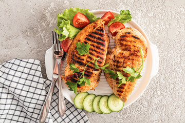 delicious healthy dietary food. two pieces of grilled chicken breast fillet on a white serving plate with vegetables. vegetarian food.