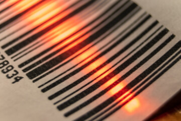 Red laser barcode reader scanning a bar code. Macro bar code business
