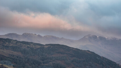 Stunning Winter sunrise landscape view from Loughrigg Fell towards Langdale Pikes and Pike O'Blisco in the Lake District