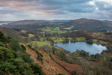 Naklejka premium Stunning colorful Winter sunrise golden hour landscape view from Loughrigg Fell across the countryside in the Lake District