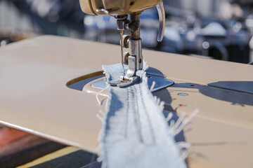 Sewing machine makes a seam on fabric. Sewing process close-up. The tailor works on a sewing machine. Selective focus.