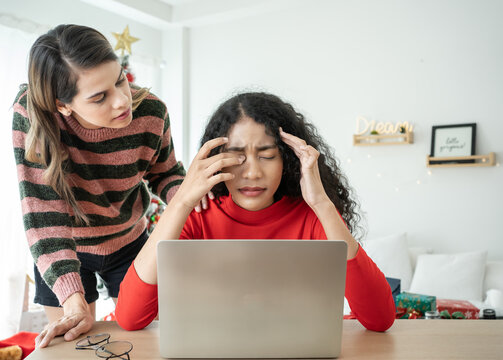 Young Frustrated Woman Working At Home Desk In Front Of Laptop Suffering From Chronic Daily Headaches. Take Care By Her Family Couple Girlfriends.