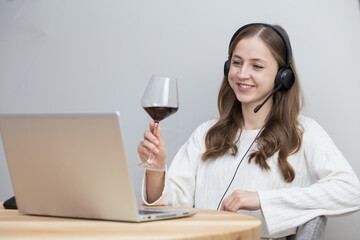 beautiful girl doing team building at home with laptop and drinking red wine