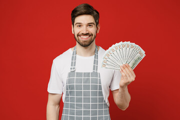 Young smiling rich male housewife housekeeper chef cook baker man wear grey apron hold in hand fan...