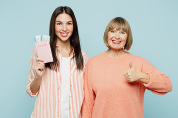Elder parent mom with young adult daughter two women wear casual clothes hold passport ticket isolated on plain blue background Tourist travel abroad in free time rest getaway Air flight trip concept