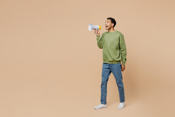 Full body young man of African American ethnicity wear green sweatshirt hold in hand megaphone...