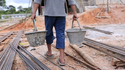 Poor boy working on a construction site. anti child labor Abuse, oppression or coercion, forced child labor Human trafficking. 4K slow motion.