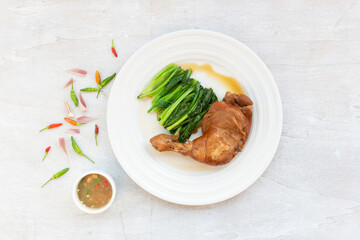 Healthy food chicken braised has kale garlic chili sauce in plate on white wood table.