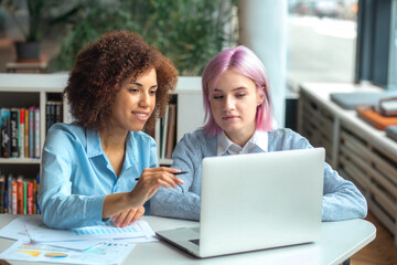 Successful African American female executive director communicates with his employee in a modern office, discussing something. Achieving success together