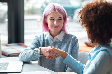 Recruitment concept. Handshake happy young woman with a recruiter after a successful job interview for her first job