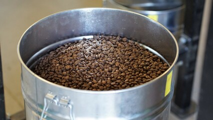 geröstete Kaffeebohnen in Fass aus Metall, Kaffeerösterei