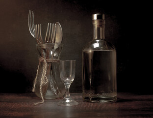 Stylized still life with a bottle of vodka or moonshine with a glass